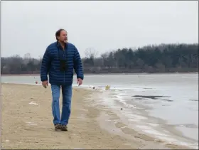  ?? COURTESY OF BILL UHRICH ?? Ed Barrell walks along the frozen shoreline at Blue Marsh Lake.