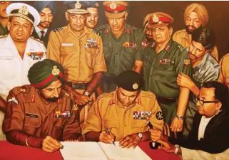  ?? PHOTOGRAPH­S: INDIAN ARMY ?? Lt General A.A.K. Niazi signing the Instrument of Surrender under the gaze of Lt General J.S. Aurora. Standing behind (L-R) Vice Admiral Krishnan, Air Marshal Dewan, Lt General Sagat
Singh, Lt General J.F.R. Jacob (with Flt Lt Krishnamur­thy peering...