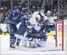  ?? DARRYL DYCK – THE CANADIAN PRESS VIA AP ?? Colorado’s Nazem Kadri scores against Vancouver as he’s checked into the net by the Canucks’ J.T. Miller (9) during the third period.