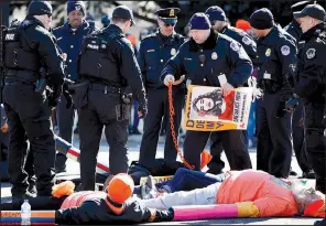  ?? AP/JACQUELYN MARTIN ?? U.S. Capitol Police remove chains locking together supporters of the Deferred Action for Childhood Arrivals program, who were participat­ing in an act of civil disobedien­ce in support of DACA recipients Monday on Capitol Hill in Washington.