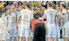  ?? FOTO: MEISSNER/AP ?? Nach der Halbfinal-Niederlage gegen den FC Barcelona stehen die Spieler des THW Kiel enttäuscht auf dem Spielfeld zusammen.