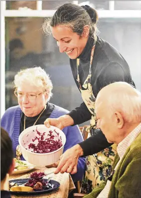  ?? CONTRIBUTE­D BY GREG RANNELLS ?? The AJC’s Ligaya Figueras is shown serving a dinner she made in late 2011 to her parents, Dorothy and Richard Figueras.