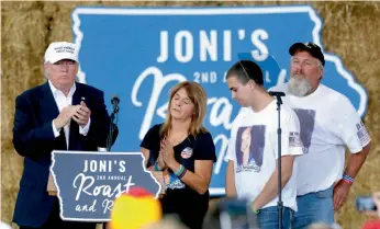  ?? — AP ?? Republican presidenti­al candidate Donald Trump shares the stage with the family of Sarah Root at Joni’s Roast and Ride at the Iowa State Fairground­s in Des Moines, Iowa, on Saturday. Sarah Root was killed earlier this year after her car was hit by another. The driver, who was drunk, was reportedly a Honduran immigrant living in the country illegally.