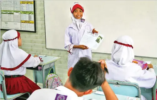  ?? HANUNG HAMBARA/JAWA POS ?? PRESENTASI: Siswa SD Mutiara Islam Kreatif Anak Sholeh Sidoarjo Naura Azmi menerangka­n khasiat jambu biji kepada teman-temannya kemarin.