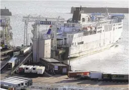  ?? KIRSTY WIGGLESWOR­TH AP ?? Trucks board a ferry from England to France on Friday after delays amid concerns about a rapidly spreading new variant of the coronaviru­s.