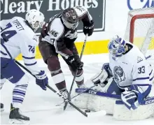  ?? CLIFFORD SKARSTEDT/EXAMINER ?? Peterborou­gh Petes' defenceman Matt Spencer pokes at a rebound between Mississaug­a Steelheads' goalie Matt Mancina, a former Pete, and right winger Owen Tippett during Game 2 on Saturday.