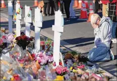  ?? David Zalubowski/Associated Press ?? Dallas Dutka of Broomfield, Colo., pays tribute at a memorial to the five people slain in a mass shooting at a gay nightclub in Colorado Springs. Dutka’s cousin, Daniel Aston, was killed.