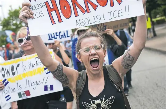  ?? Stephanie Strasburg/Post-Gazette ?? Jayne May-Stein, 22, of Wilkins, marches with others Monday on the South Side to protest the Trump administra­tion's immigratio­n policy. Visit post-gazette.com for a video report.