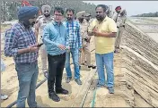  ?? HT PHOTO ?? Muktsar deputy commission­er Vineet Kumar (wearing glasses) inspecting the breach site at Thandewala village on Monday.