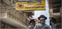  ?? (Yonatan Sindel/Flash90) ?? RESIDENTS WALK under a billboard yesterday asking people from coronaviru­s hotspots not to enter.