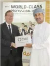  ??  ?? Tarik bin Shabib receiving the IiP Plaque from Hamish Cowell , British ambassador to Oman.