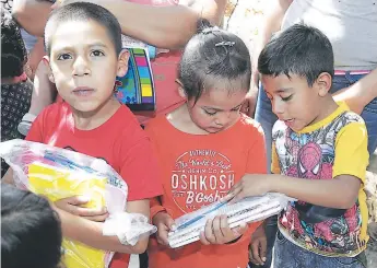  ??  ?? Los pequeños observaban sus paquetes educativos luego de tenerlos entre sus manos.