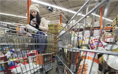  ?? GERRY KAHRMANN / POSTMEDIA NEWS FILES ?? Volunteer Joanne Tan checks the expiration dates of food items donated to the Greater Vancouver food bank.