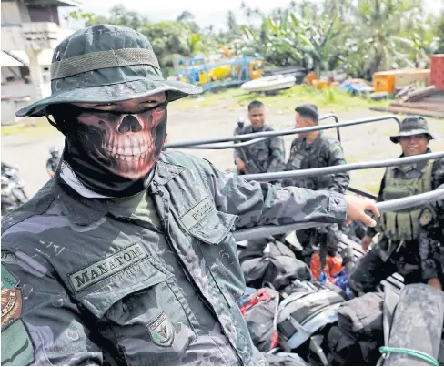  ??  ?? BATTLE FAR FROM OVER: Members of the Philippine National Police Special Action Force ride on a truck in Iligan as government forces continue their assault against insurgents from the Maute group who have taken over large parts of Marawi City,...