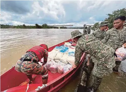  ?? NSTP PIC BY RONI KAWI ?? Rescuers preparing food supplies for flood victims in Bintulu yesterday.