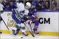  ?? ADAM HUNGER — THE ASSOCIATED PRESS ?? New York Rangers left wing Chris Kreider (20) and Vancouver Canucks defenseman Quinn Hughes (43) battle for the puck during a game on Sunday.