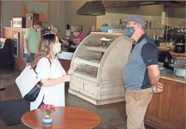  ?? Doug Walker ?? Rome’s Downtown Developmen­t Director Aundi Lesley (left) introduces herself to Doug Bowling, owner of Doug’s Deli Downtown, on Broad Street. Getting to know the downtown merchants has been a top priority for Lesley, who took over the post last month.