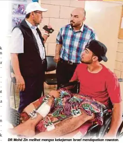  ??  ?? DR Mohd Zin melihat mangsa kekejaman Israel mendapatka­n rawatan.