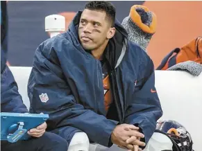  ?? AP file photo ?? Denver Broncos quarterbac­k Russell Wilson sits on the bench during the second half of a game against the Los Angeles Chargers on Dec. 31 in Denver. The Broncos have informed Wilson that he will be released soon.