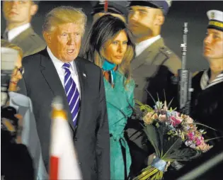  ?? Czarek Sokolowski ?? The Associated Press President Trump and first lady Melania Trump walk past the honor guards as they arrive Wednesday in Warsaw, Poland, ahead of the Group of 20 summit in Germany.