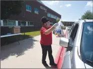  ??  ?? Maria Aguilar of Bentonvill­e brings meals to waiting students June 15 at Bentonvill­e High School. The University of Arkansas for Medical Sciences will expand partnershi­ps with school districts to implement a school nutrition enrichment program in Northwest Arkansas to provide healthier food choices for students. Go to nwaonline.com/200704Dail­y/ for photo galleries. (NWA Democrat-Gazette/J.T. Wampler)