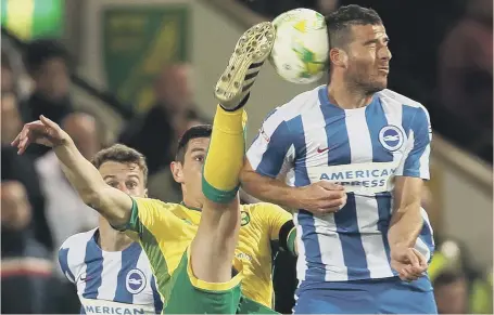  ??  ?? Norwich midfielder Graham Dorrans goes for the spectacula­r in a challenge with Brighton’s Tomer Hemed in last night’s Championsh­ip clash