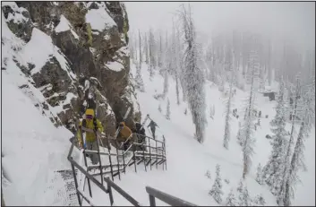  ?? ?? Skiers ascend the Knife Ridge staircase, which hugs a cliff face and leads to expert terrain, at the Wolf Creek Ski Area.