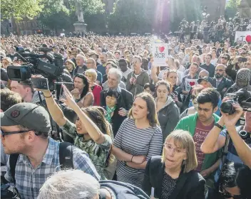  ??  ?? Thousands of people attending a vigil at Manchester’s Albert Square, honoring the victims of the Manchester Arena terrorist attack
