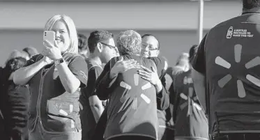  ?? PAUL RATJE/GETTY-AFP ?? Walmart staffers gather as the retail store reopens Thursday in El Paso, Texas, after the mass shooting in August.