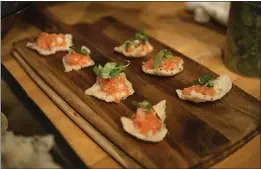  ??  ?? Cured trout with pickled daikon radish on flat sesame rice patties is prepped for guests at San Ramon’s new Slanted Door restaurant.