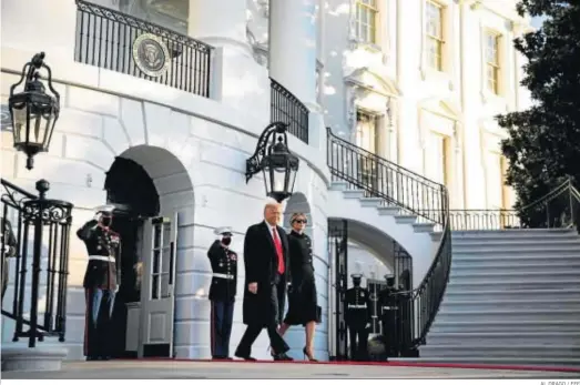  ?? AL DRAGO / EFE ?? El presidente saliente de EEUU, Donald Trump, abandona ayer la Casa Blanca de la mano de su esposa, Melania.