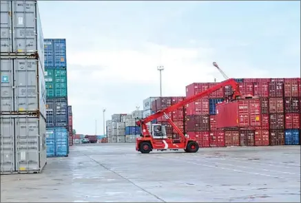  ?? SAHIBA CHAWDHARY ?? A vehicle lifts containers for shipping earlier this year at the Sihanoukvi­lle Autonomous Port.