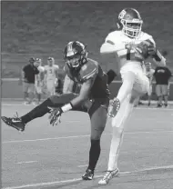  ?? BEA AHBECK/NEWS-SENTINEL ?? Tracy's Trevor Pope II makes a catch as Tokay's Chase Howell defends during their conference game at the Grape Bowl in Lodi on Friday.