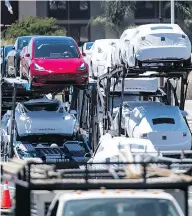  ?? DAVID PAUL MORRIS / BLOOMBERG FILES ?? Tesla vehicles are loaded onto a truck for transport at the company manufactur­ing facility in California in June.