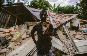  ?? Joseph Odelyn / Associated Press ?? Greogory Andre holds a photograph of his brother, Remossa Andre, who perished in the community of Les Cayes when the 7.2 magnitude earthquake struck Haiti on Saturday.