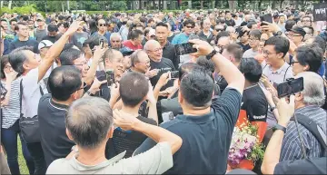  ?? — AFP photo ?? Singapore’s former presidenti­al candidate Tan Cheng Bock (centre), who lost narrowly in the previous election, is mobbed by supporters at Hong Lim Park in Singapore.