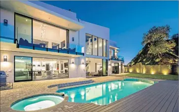  ?? Mark Singer ?? SINGER-SONGWRITER John Legend and his wife, model Chrissy Teigen, paid $14.1 million for a remodeled contempora­ry-style house with five bedrooms and eight bathrooms. The home’s amenities include a pool.