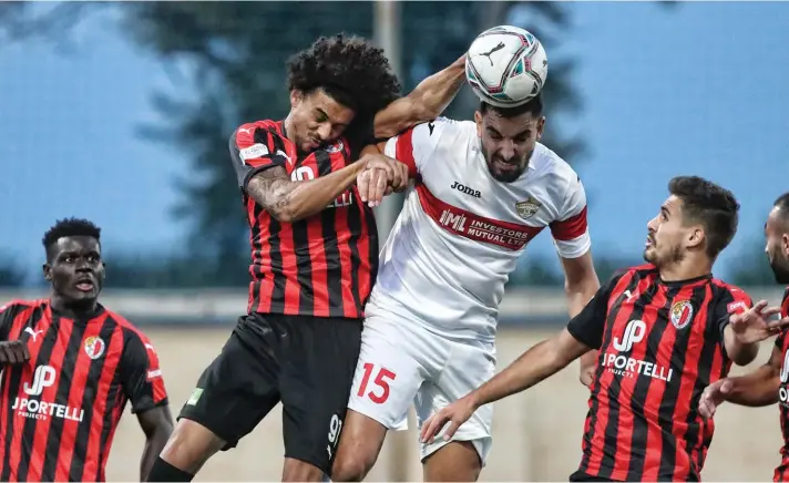  ??  ?? Photo: Hamrun's Emerson Marcelina (L) vies for the ball with Michael Johnson of Balzan during the first half.