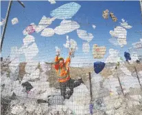  ?? DON HEALY FILES ?? Plastic bags cannot be recycled and often wind up in landfills. Here, Dustin Caulderwoo­d works on spring cleanup along the south fence line at the Regina landfill in April 2015.