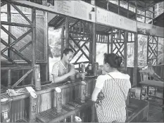  ??  ?? A tourist buys bamboo liqueur, which is made by injecting and ageing alcohol inside the plant, in the Yibin bamboo forest.