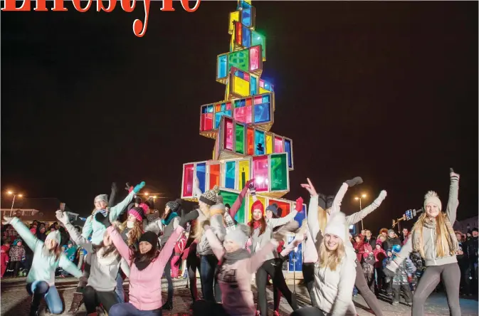  ??  ?? People dance in front of a12-meter-high Christmas tree constructe­d of 121 old windows that come from local old houses as it is illuminate­d in Rakvere, Eastern Estonia yesterday.—AFP