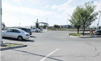  ?? DARREN MAKOWICHUK ?? Calgary Transit says the owners of these three cars parked at the Crowfoot CTrain station Tuesday evening were told their cars would have to remain on the lot for 24 hours while officials looked into what caused a depression in the pavement. Officials said they would use a camera scope to check out the problem.