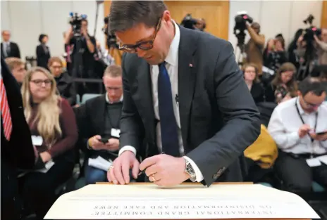  ?? AP PHOTO ?? Prince George-Peace River-Northern Rockies MP Bob Zimmer signs an agreed declaratio­n of principles on disinforma­tion and fake news at the beginning of a press conference in London on Tuesday. Eight different parliament­s from all over the world, known as the Internatio­nal Grand Committee on Disinforma­tion and Fake News, gathered for a special evidence session.