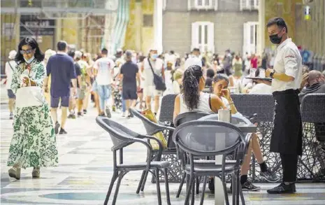  ??  ?? »Un camarero atiende a los clientes en la terraza de un restaurant­e en Nápoles, Italia.