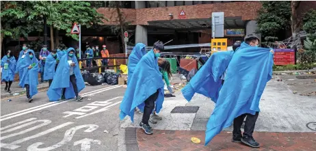  ?? (AFP) ?? Protesters leave from the main entrance to Hong Kong Polytechni­c University campus in the Hung Hom district in Hong Kong on Tuesday