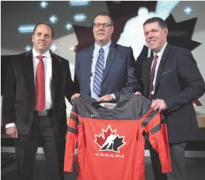  ?? CP FILE PHOTO ?? Hockey Canada president and CEO Scott Smith, right, senior manager Shawn Bullock, left, and head scout Brad McEwen, pose with a jersey after announcing the players invited to Canada’s National Junior Team selection camp in 2017.