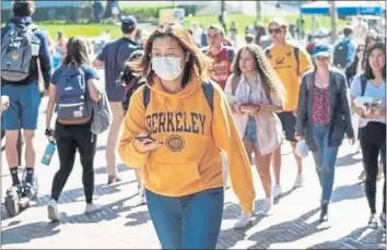  ?? GABRIELLE LURIE — SAN FRANCISCO CHRONICLE ?? Monica G. wears a mask while walking through the UC Berkeley campus. The 10-campus system has faced significan­t revenue losses during the pandemic, leading UC to seek increased aid in the 2021-22 state budget to make up for most of it.