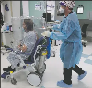  ??  ?? A man with covid-19, wearing a protective cover, is transferre­d from the emergency room to a covid-19 unit at Starr County Memorial Hospital in Rio Grande City, Texas. For nearly a month, the Rio Grande Valley pleaded for a field hospital, but not until Monday was one ready.