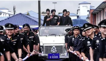  ??  ?? Amar Singh (centre) waves to the crowd during his retirement farewell parade. — Bernama photo