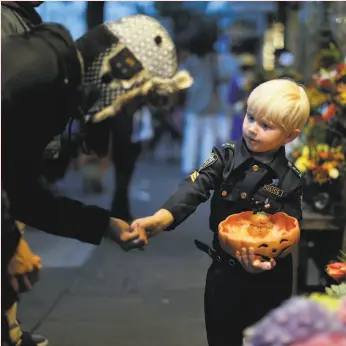 ?? Carlos Avila Gonzalez / The Chronicle 2016 ?? Vitaly Van De Sande, 4, hands out candy to passersby at his family’s flower shop on 24th Street in San Francisco on Halloween in 2016.